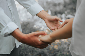Hand pose attaching wedding ring to ring finger - obrazy, fototapety, plakaty