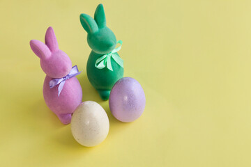 Composition of bunnies and Easter eggs on a pastel background