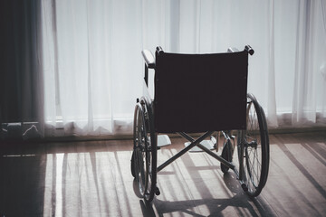 A wheelchair is sitting in a room with white curtains