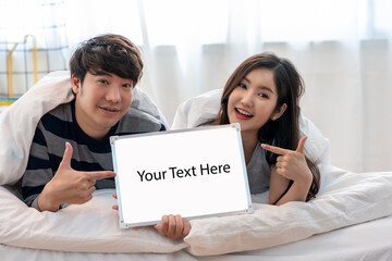 A couple is holding a white board with the words "Your text here" written on it