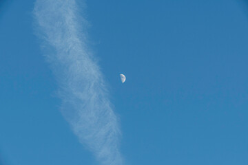 Halbmond neben weißem Wolkenband im blauen Himmel - obrazy, fototapety, plakaty