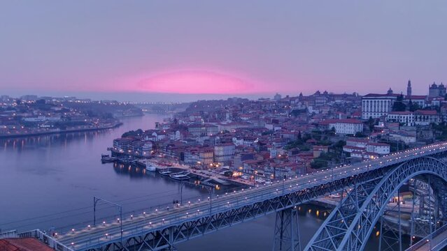 Day to night transition aerial panoramic view of the historic city of Porto, Portugal timelapse with the Dom Luiz bridge. Colorful sky after sunset