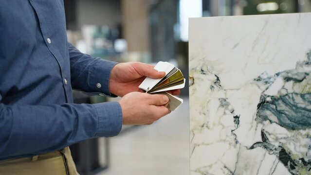 Male hands choosing metal decor or fugue compare with ceramic tile