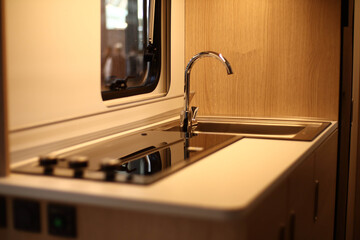 Interior design of a kitchen in a camper on wheels. Caravan, motorhome. Mobile home. Stove and...