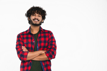 Confident young Indian man in casual clothes with arms crossed looking at camera isolated over white background. Happy Hindi boy with toothy smile