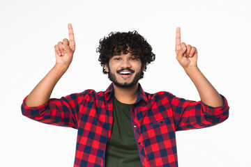 Happy young Hindi man showing upwards copyspace place isolated over white background. Handsome...