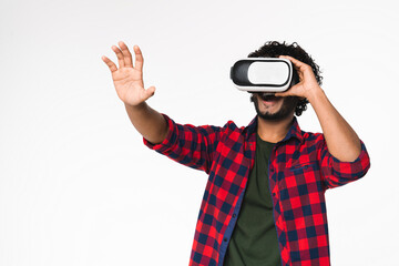 Active young Indian man using VR glasses for playing isolated over white background. Modern Hindi...