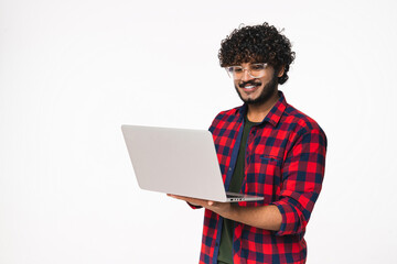 Smiling young Indian man using laptop for remote job isolated over white background. Happy Hindi...