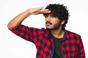 Young Hindi man in casual clothes looking far away isolated over white background. Indian...