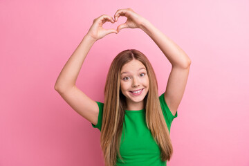 Fototapeta na wymiar Photo portrait of pretty teenager girl raise hands show heart gesture dressed stylish green outfit isolated on pink color background