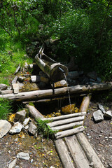 Water recovery in the mountains through wooden pipes. - 775059489