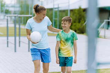 A female coach and a young football player go to training