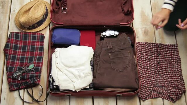 Faceless hands packing luggage for travel. Top view of unrecognizable woman putting clothes into suitcase getting ready. Tourism and lifestyle concept. End of quarantine. Wunderlust for adventure