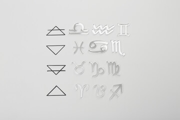 Zodiac triplicity. Four elements and corresponding signs on grey background, flat lay