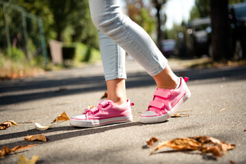Cropped photo of carefree small girl legs wear pink shoes enjoying sunny weather walking outside...