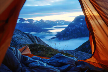 Mountain campsite view from inside a tent at dawn, overlooking a mist-covered valley