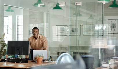 Smiling African businessman working over his desk in an office