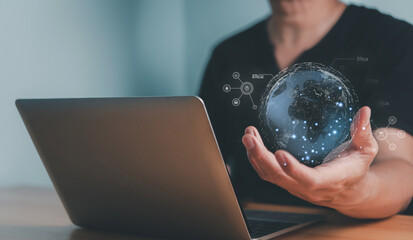 Person using laptop with holographic global network visualization for strategic business planning..