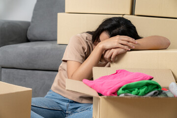 The young woman is tired from moving and packing her belongings as she moves to a new house