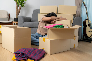 The young woman is tired from moving and packing her belongings as she moves to a new house