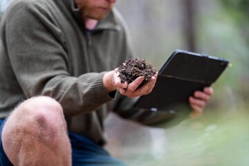 australian soil scientist. regenerative organic farmer, taking soil samples and looking at plant...