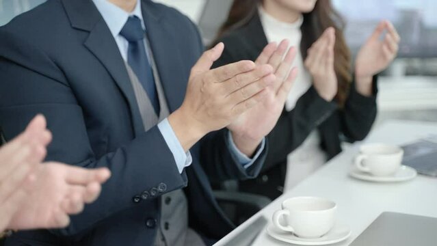 Close-up of businessman's hands clapping while attending a seminar
