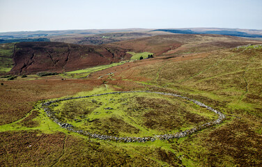 Grimspound prehistoric Late Bronze Age site on Dartmoor, Devon, England. Dates from 1300 BC. Hut circles and enclosure wall. Aerial looking NW