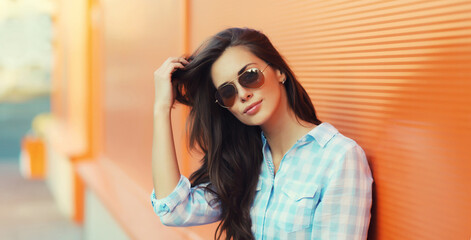 Portrait beautiful brunette young woman in sunglasses posing in the city