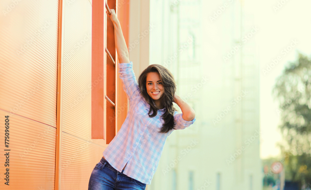 Wall mural Portrait beautiful happy smiling brunette young woman posing in the city