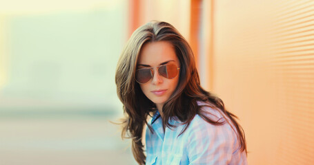 Portrait beautiful brunette young woman in sunglasses posing in the city