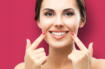 Image of happy excited woman showing pointing toothy smile. Face portrait of optimistic girl, isolated against red background. Optimism or dental dent health care ad concept.