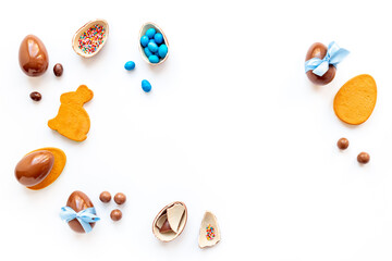 Easter background. Chocolate Easter eggs in blue ribbon with bunny cookies