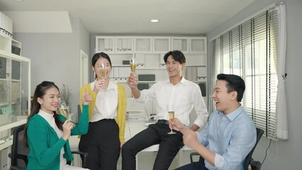 The business team is drinking wine to celebrate success in the office.
