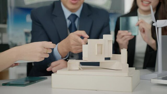 businessman and an architect are brainstorming building designs at a meeting.
