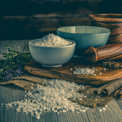 Dead Sea Salt on wooden table background. Herbs, spices and dried food baking ingredient. Mortar...