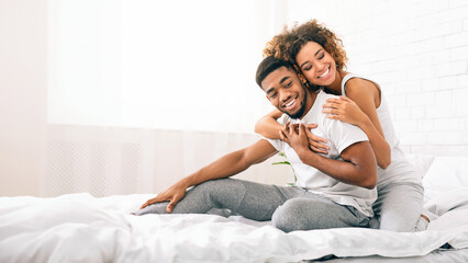 Happy couple flirting in morning on comfortable bed