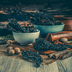MULATO CHILLI PODS on wooden table background. Herbs, spices and dried food baking ingredient. Mortar and different spices. Cottage kitchen. Product Photography - obrazy, fototapety, plakaty