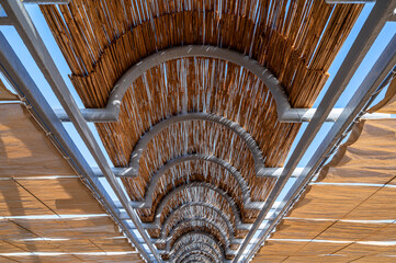 Dachkonstruktion aus Stoffbahnen und Bambusmatten als flächendeckender Schattenspender