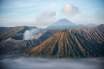 Mount Bromo with smoke, Mount Batok at front, and Mt Gunung Semeru at back, volcano, eruption,...