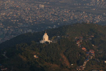 the outlook of Peace Pagoda in hill area with the townscape of Pokhara - 775113872