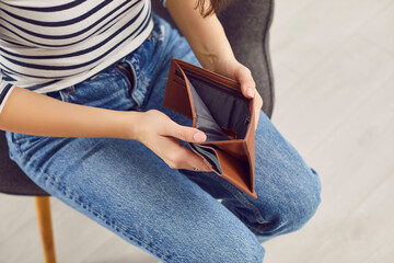 Woman opening empty wallet, poor person having no money in purse, bankrupt with financial problems....