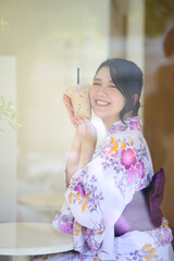 Japanese woman smile with yukata dress and milk tea in hand - 775117471