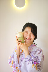 Japanese woman with yukata dress and green tea drink in hand - 775117854