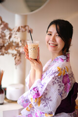 Japanese woman smile with yukata dress and milk tea in hand - 775118074