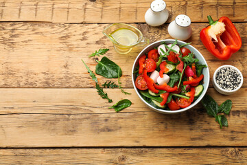 Tasty fresh vegetarian salad on wooden table, flat lay. Space for text