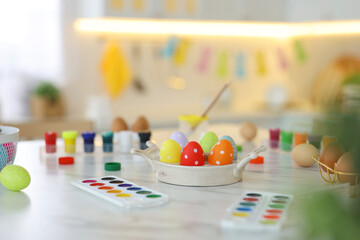 Happy Easter. Painted eggs and watercolor on white marble table indoors