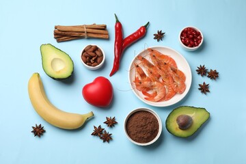 Natural aphrodisiac. Different food products and red decorative heart on light blue background,...