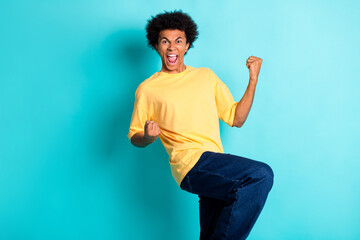 Photo of overjoyed man with afro hairdo wear oversize t-shirt clenching fists scream yeah win bet...