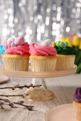 Tasty cupcakes with Easter decor on wooden table, closeup