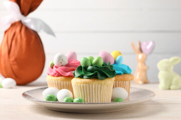 Tasty cupcakes with Easter decor on wooden table